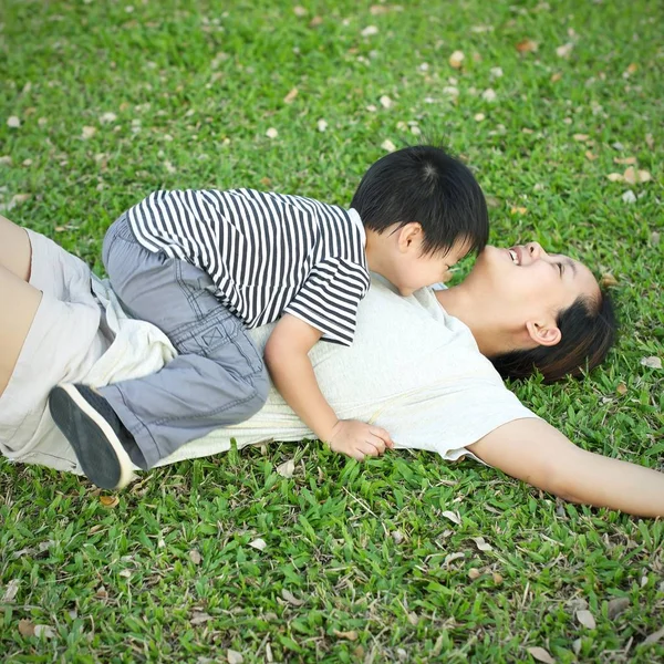 Çayırda genç anne üzerinde döşeme çocuk