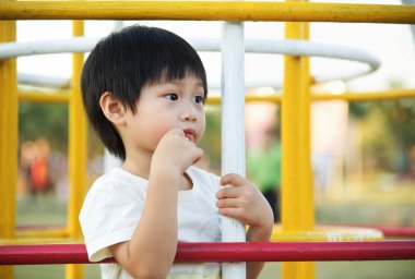 Küçük Asyalı çocuk bekleyen ve onun üst playgroun adlı arıyorsunuz