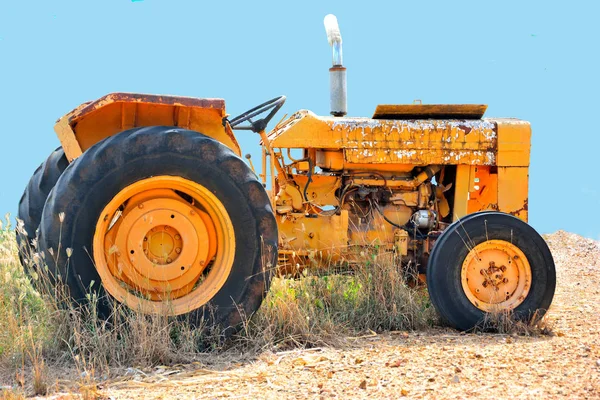 Eski paslı turuncu traktör.