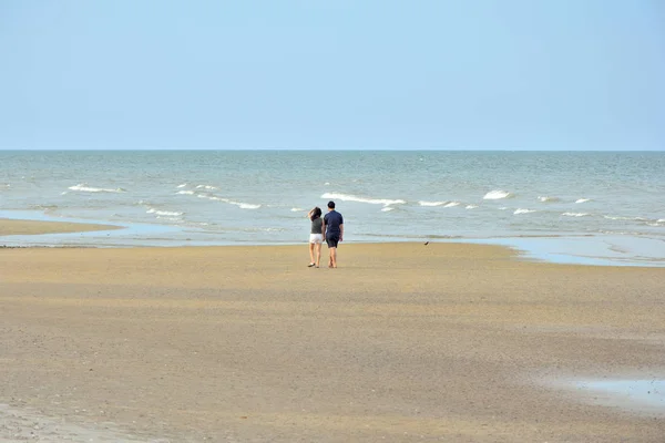 男性和女性的夫妇在海滩上行走 — 图库照片