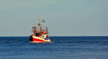 Bir balıkçı tekne deniz mavi gökyüzü arka planda 