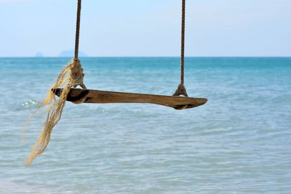 Nahaufnahme von Holzschaukel am Strand mit sonnigem Tag Meereshintergrund — Stockfoto