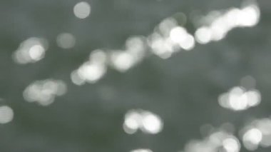 Hangi denizden - sorunsuz loop.burred su yansıtılır dalgalı su yüzeyi ufuk atış güneş güzel bokeh ile bakıyor