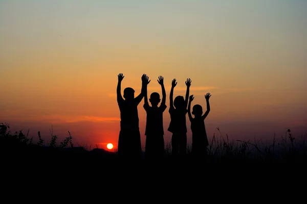 Черный Силуэт Четверых Детей Стоящих Вместе Фоне Заката Небо — стоковое фото