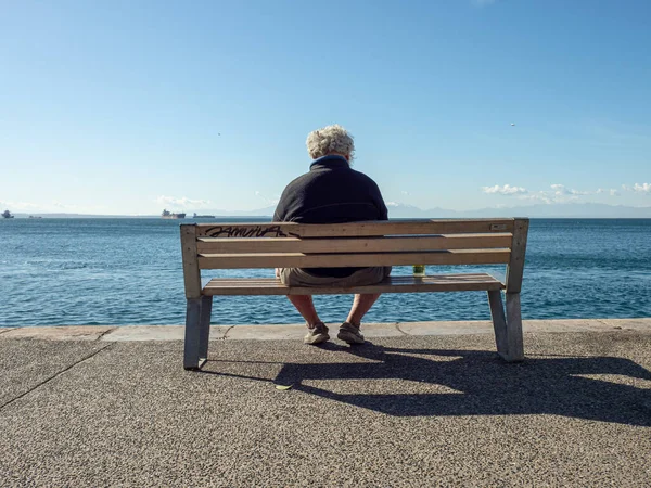 Ein Mann Auf Einer Bank Meer Thessaloniki Stockbild