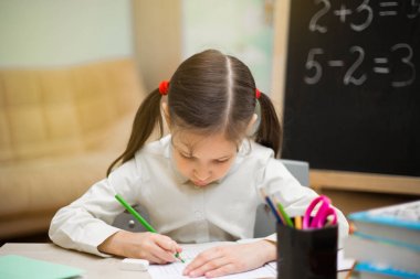 Güzel genç kız evde tahtaya öğretiyor. Okul öncesi ana sayfa eğitim.