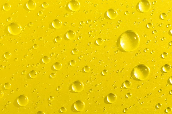 Gotas de agua sobre fondo de vidrio amarillo —  Fotos de Stock