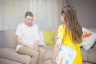Çocuk kızı anne tebrik ve resim verir. Anne ve kız gülümseyerek ve sarılma. Aile tatili ve mutluluk. 
