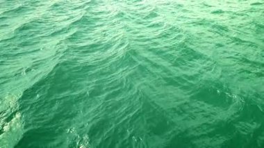 Ağır çekimde, loopable yeşil okyanus yüzeyinin üzerinde uçmak