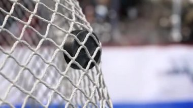 Hokey diski net içine mavi bir şerit ile bir hokey kurullarında uçar. Ağır çekimde