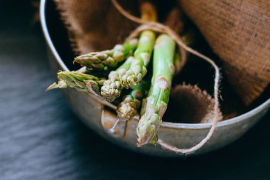Bir avuç siyah mazisi üzerinde taze yeşil kuşkonmaz