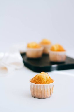 Turuncu muffins ön planda ve siyah bir tepsi