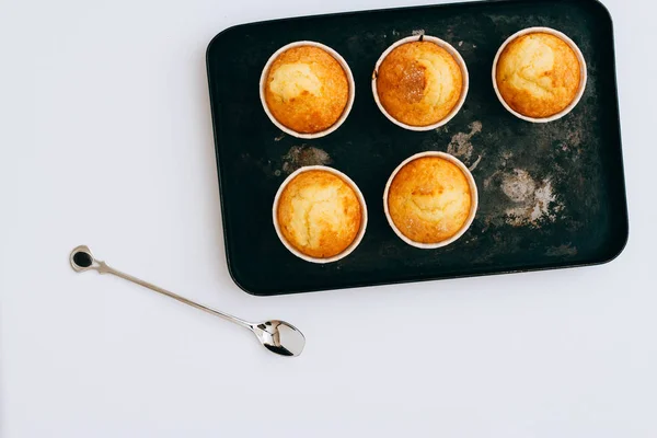 Muffins faits maison dans un plateau noir sur fond blanc . — Photo