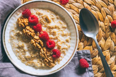 Sabah kahvaltı, yulaf ezmesi süt ile ahududu ve ceviz, üstten görünüm