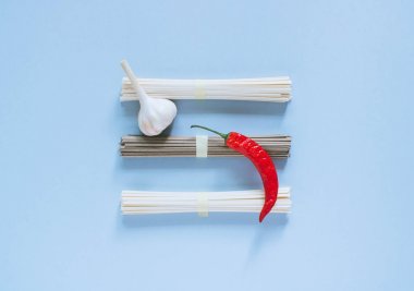 Asya Erişte udon ve soba, kırmızı biber, sarımsak parlak mavi bir arka plan. Minimalizm. Düz yatıyordu.