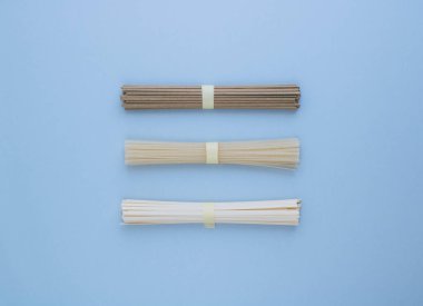 Asya pirinç noodle, udon ve parlak mavi zemin üzerine soba. Minimalizm. Düz yatıyordu.