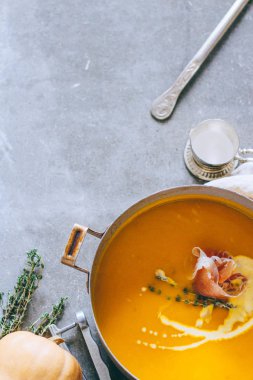 Güveç jamon, sarımsak, kekik ve krem, gri bir arka planda üstten görünüm ile kabak çorbası