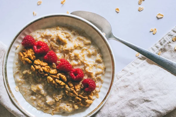 Sabah kahvaltı, yulaf ezmesi süt ile ahududu beyaz bir arka planda üstten görünüm