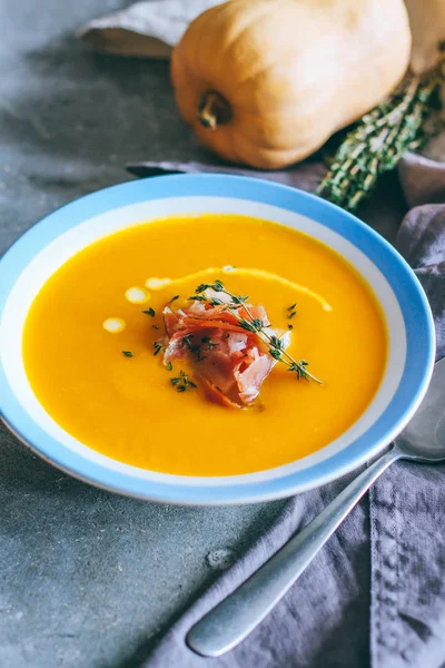 Balkabağı çorbası jamon, sarımsak, kekik ve krem, gri bir arka plan üzerine bir tabak