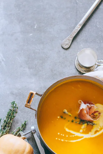 Güveç jamon, sarımsak, kekik ve krem, gri bir arka planda üstten görünüm ile kabak çorbası