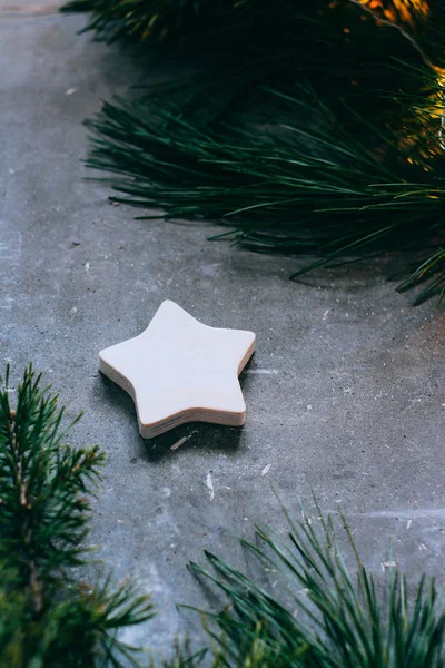 Fondo de Navidad o Año Nuevo, ramas de un árbol de Navidad y juguetes vintage, estrella de madera sobre un fondo gris. Decoración de Navidad. Una guirnalda brillante . —  Fotos de Stock