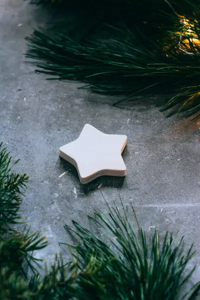 Χριστούγεννα ή Πρωτοχρονιά φόντο, κλαδιά ενός χριστουγεννιάτικου δέντρου και vintage παιχνίδια, ξύλινο αστέρι σε γκρι φόντο. Χριστουγεννιάτικη διακόσμηση. Μια λαμπερή γιρλάντα. — Φωτογραφία Αρχείου