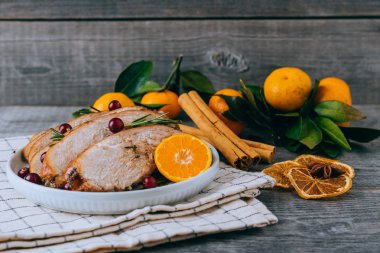 Noel yemeği için portakal dilimli fırında hindi ya da tavuk ve koyu kırsal arka planda şenlik dekorasyonu.