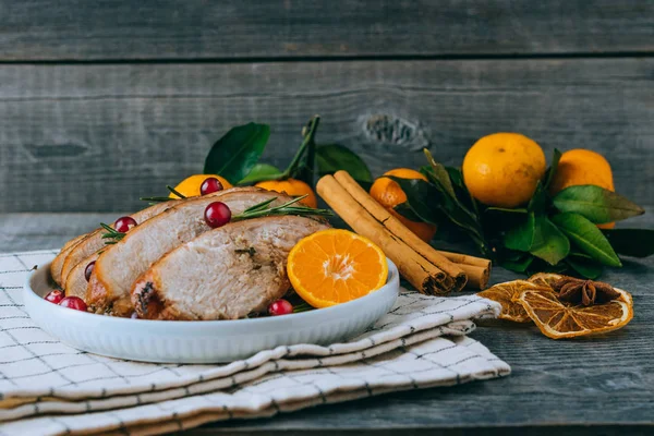 Pečený krocan nebo kuře s plátky pomeranče na talíři k vánoční večeři a slavnostní dekorace na tmavém venkovském pozadí — Stock fotografie