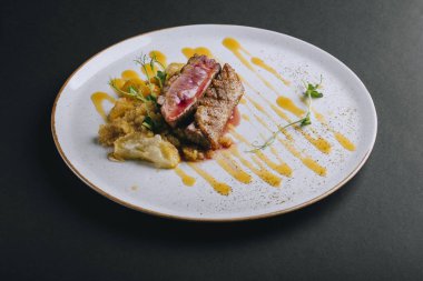 Siyah arka planda taze bezelye filizi ve kinoalı ördek göğsü filetosu.