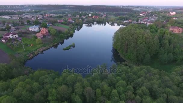 Wieś w pobliżu lasu z jeziorem. Zdjęcia lotnicze Drone — Wideo stockowe