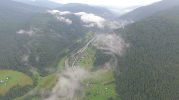 Schönes Dorf in den Bergen in der Nähe eines Waldes in den Wolken — Stockvideo