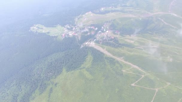 Vlucht boven het prachtige bergdorpje in de zomer haze — Stockvideo