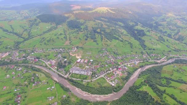 Das Dorf in einem Bergtal in der Nähe des Flusses. Luftbild — Stockvideo