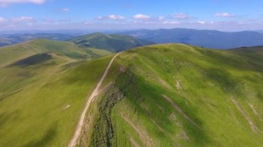 flying near mountains covered with green grass