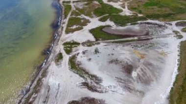 An alien looking bird`s eye view of the Black Sea shelf with enigmatic ponds and patches of weed and wetland on a sunny day in summer. Theskyscape is cloudy and dark