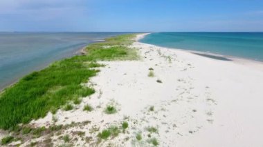A wonderful bird`s eye view of the Black Sea shelf with sandy spit, small area of greenery and bright blue waters on a sunny day in summer. The curvy yellow island looks like paradise