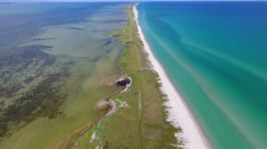 A gorgeous bird`s eye view of the Black Sea sandy spit dividing the sea waters in dark green and bright blue on a sunny day in summer. The straight yellow island looks enigmatic and encouraging