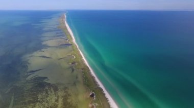 A mystic bird`s eye view of the Black Sea sandy spit dividing the sea waves in dark green and bright blue on a sunny day in summer. The straight yellow island looks picturesque and dreamlike
