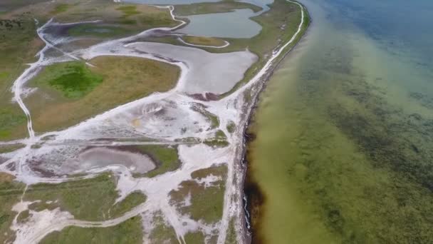 Un marcien qui regarde la côte de la mer Noire avec de mystérieux étangs blancs et des parcelles de mauvaises herbes et de terres humides par une journée ensoleillée en été. Le paysage est nuageux et sombre un peu 