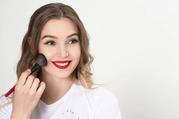 girl puts on makeup, Brush for applying makeup