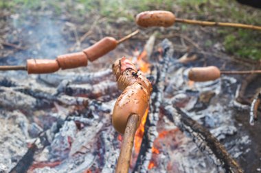 Ormanda bir yangında kızarmış sosis pişirme