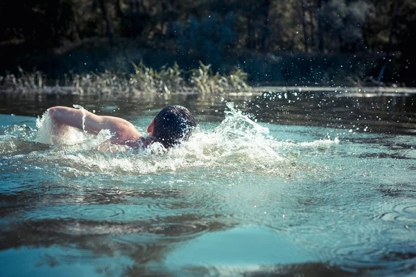 Młody człowiek pływający w rzece — Zdjęcie stockowe