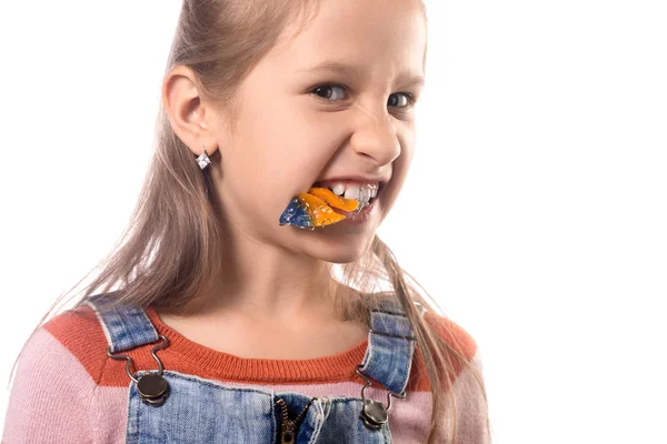 Kleines Mädchen beißt kieferorthopädisches Gerät auf weißem Hintergrund — Stockfoto