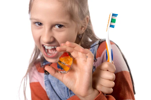 Retrato de uma menina fofa com escova de dentes e ortodontia um — Fotografia de Stock