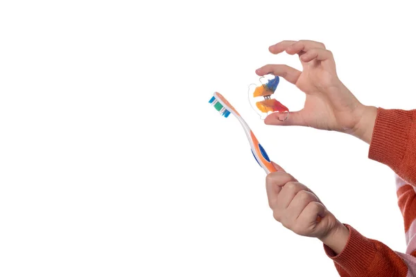 Mão de criança com aparelho ortodôntico e escova de dentes em um whit — Fotografia de Stock