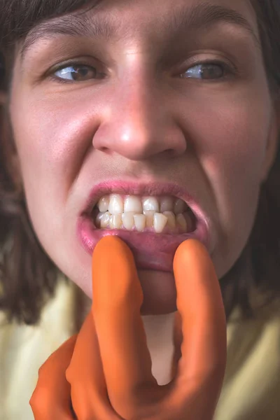 Mujer con guantes muestra sus dientes torcidos. —  Fotos de Stock