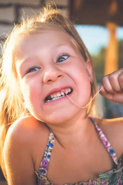 El proceso de remover un diente de bebé usando un hilo —  Fotos de Stock