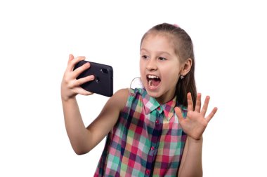Küçük şirin kız telefonuyla selfie çekiyor. Beyaz arkaplanda stüdyo fotoğrafı