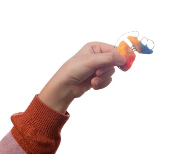 Beyaz arka planda izole edilmiş ortodontik cihazlı çocuk eli