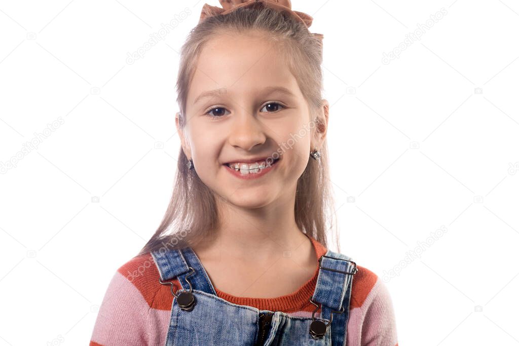 Portrait of little girl with orthodontics appliance isolated on white background.